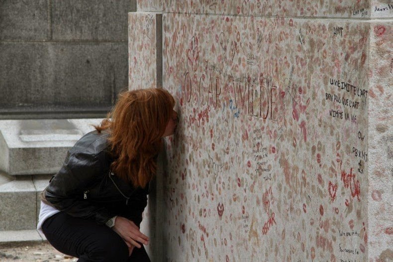 девушка целует памятник на могиле Оскара Уайльда